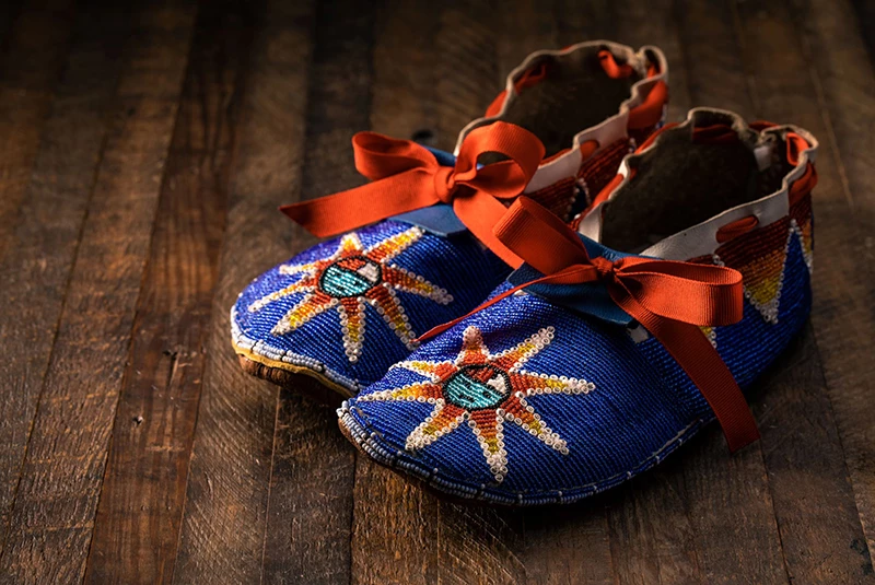 Designed Moccasin with a blue background and a sun figure